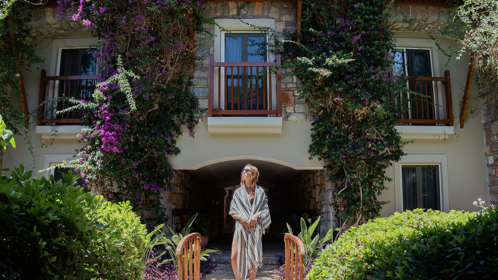 Woman standing in front of a stone building with floral decorations