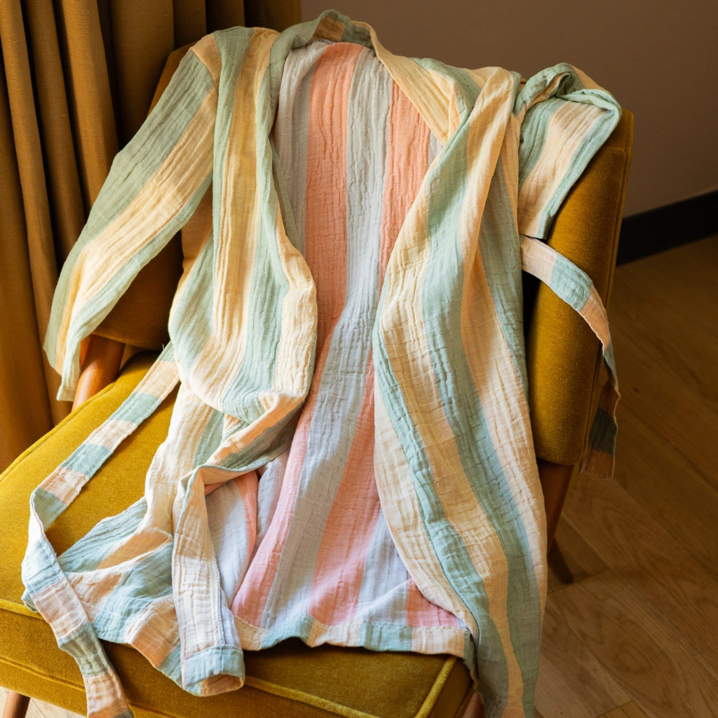 Multi-color striped bathrobe draped over a yellow chair