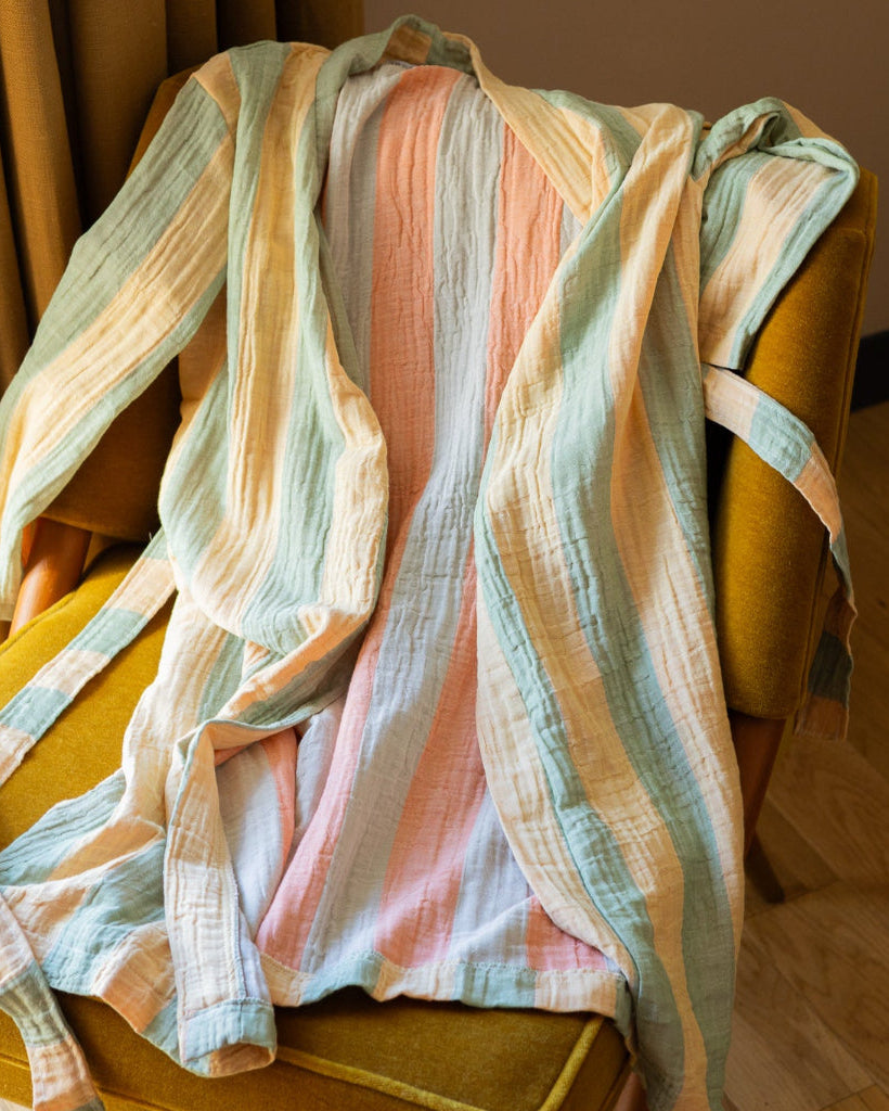 Multi-color striped bathrobe draped over a yellow chair