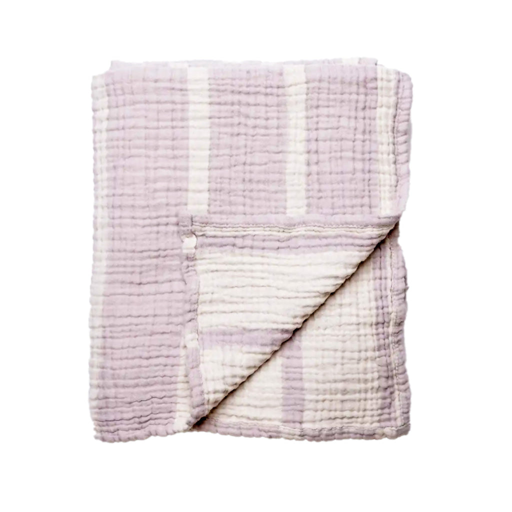 Folded lilac and white textured blanket on a white background