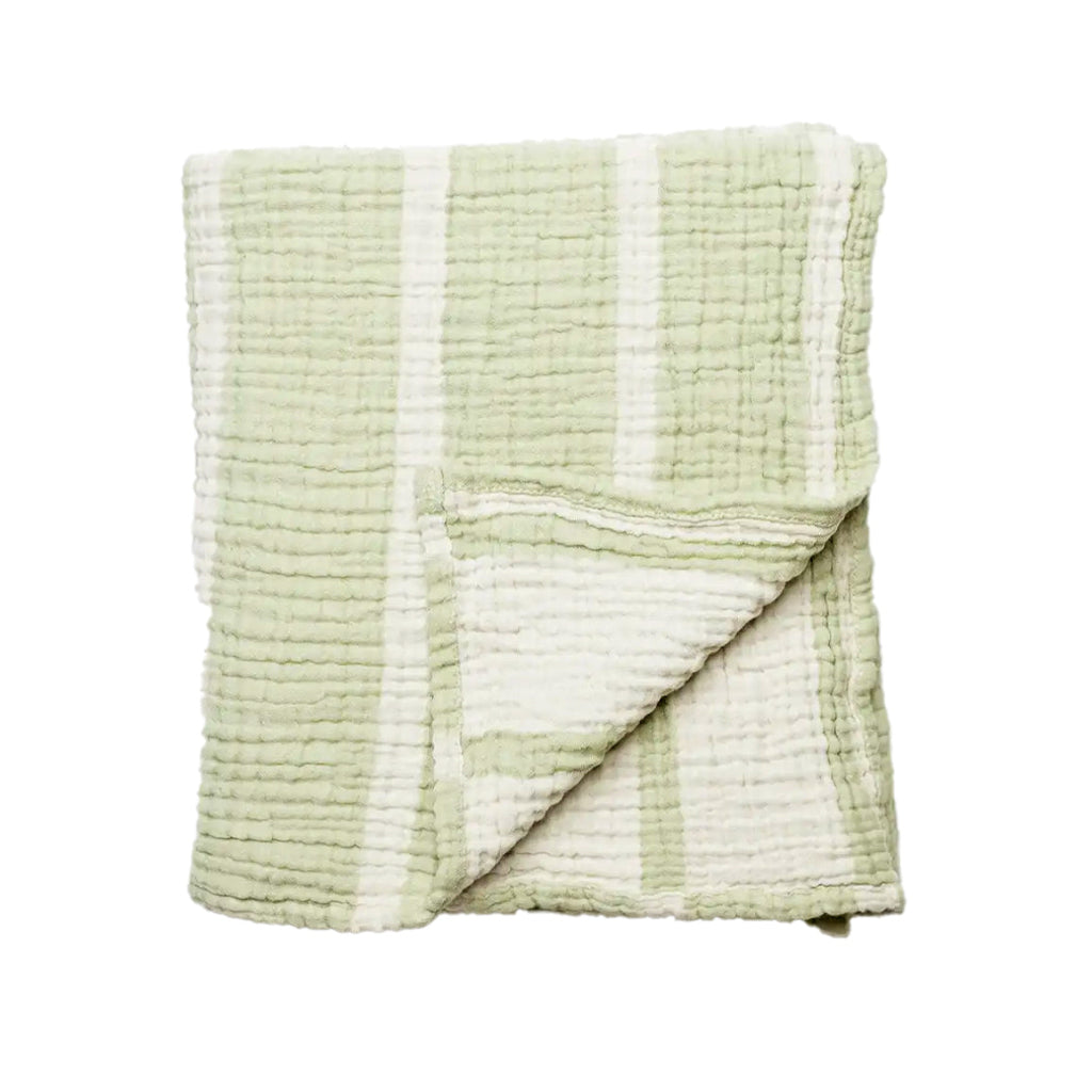 Folded green and white textured blanket on a white background