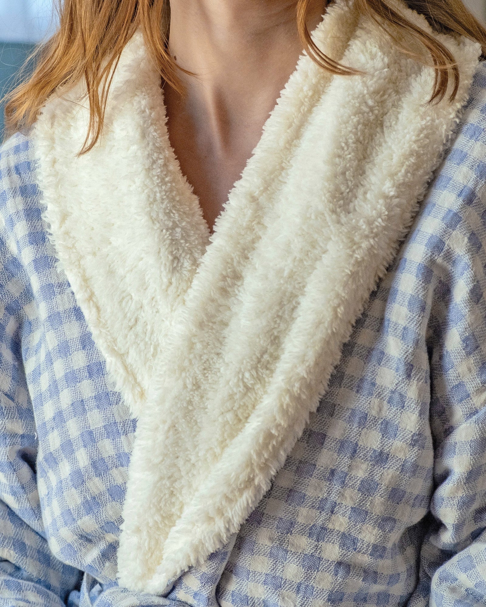 Blue checkered robe with white fleece lining worn by a young woman