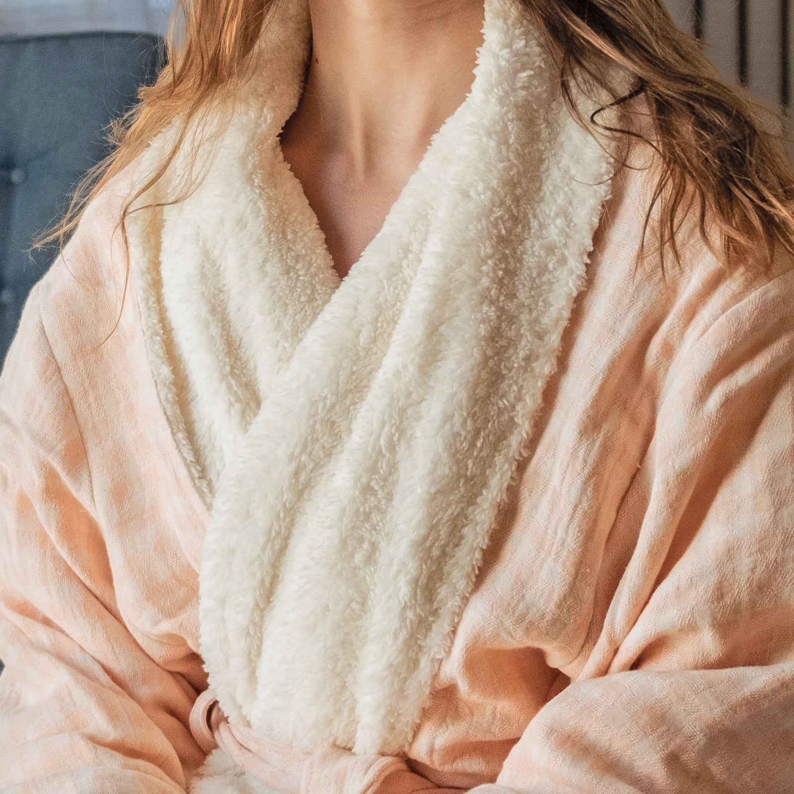 Coral checkered robe with white fleece lining worn by a young woman