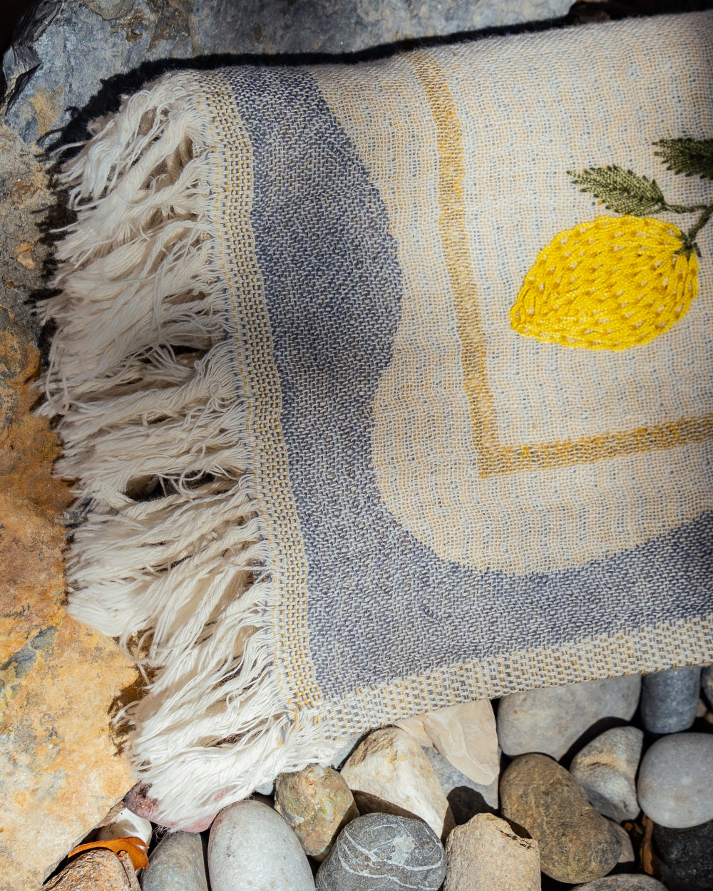 kitchen towel with lemon design on stones