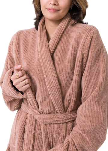 Woman in a ribbed terry cotton robe in clay from Olive & Loom standing against a white background