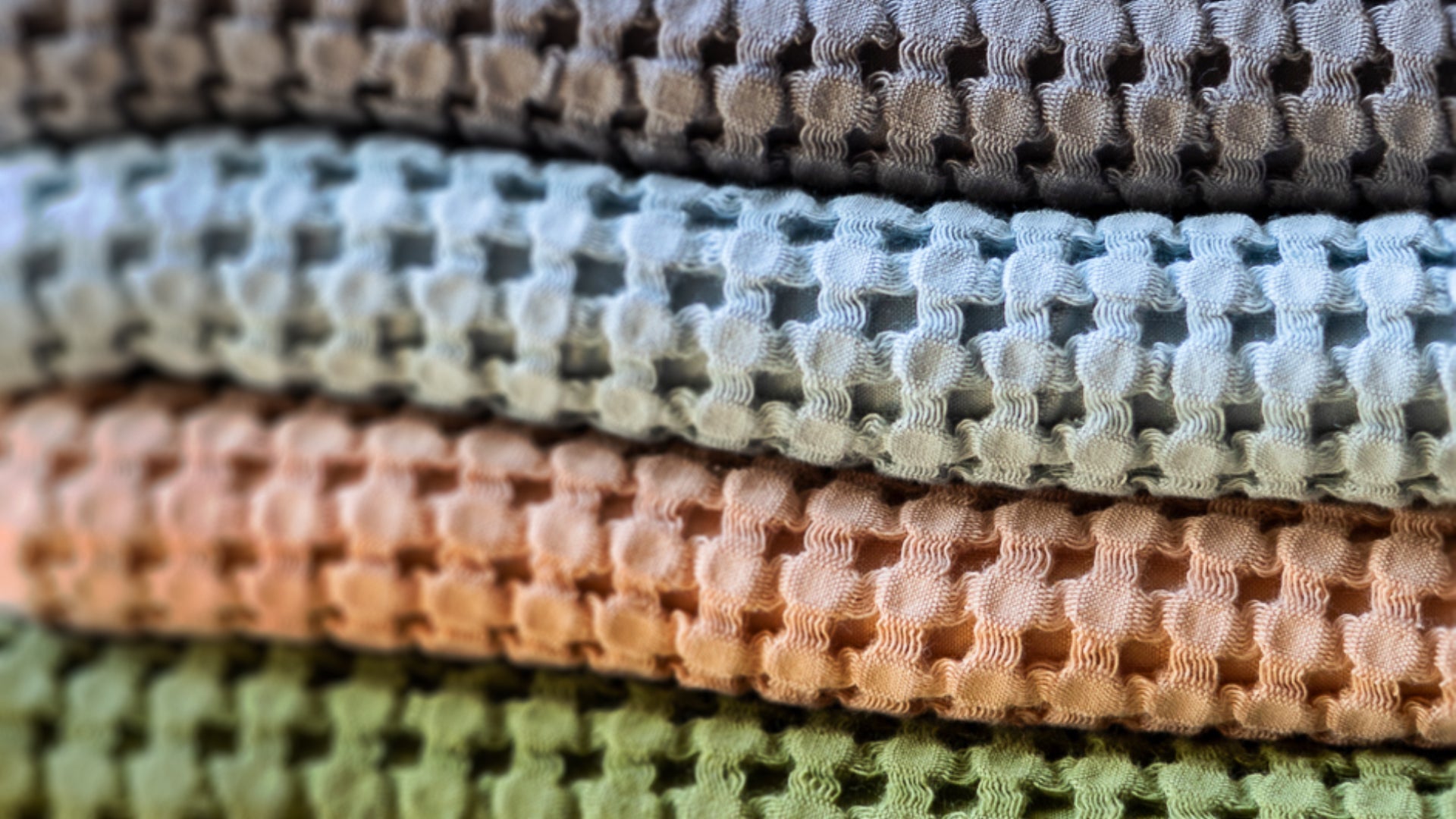 Stack of textured bath towel swatches in various colors.