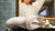 White guest towel on a black sink countertop in front of a blurred background