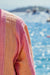 Close-up of a pink and orange robe with a blurred blue water background