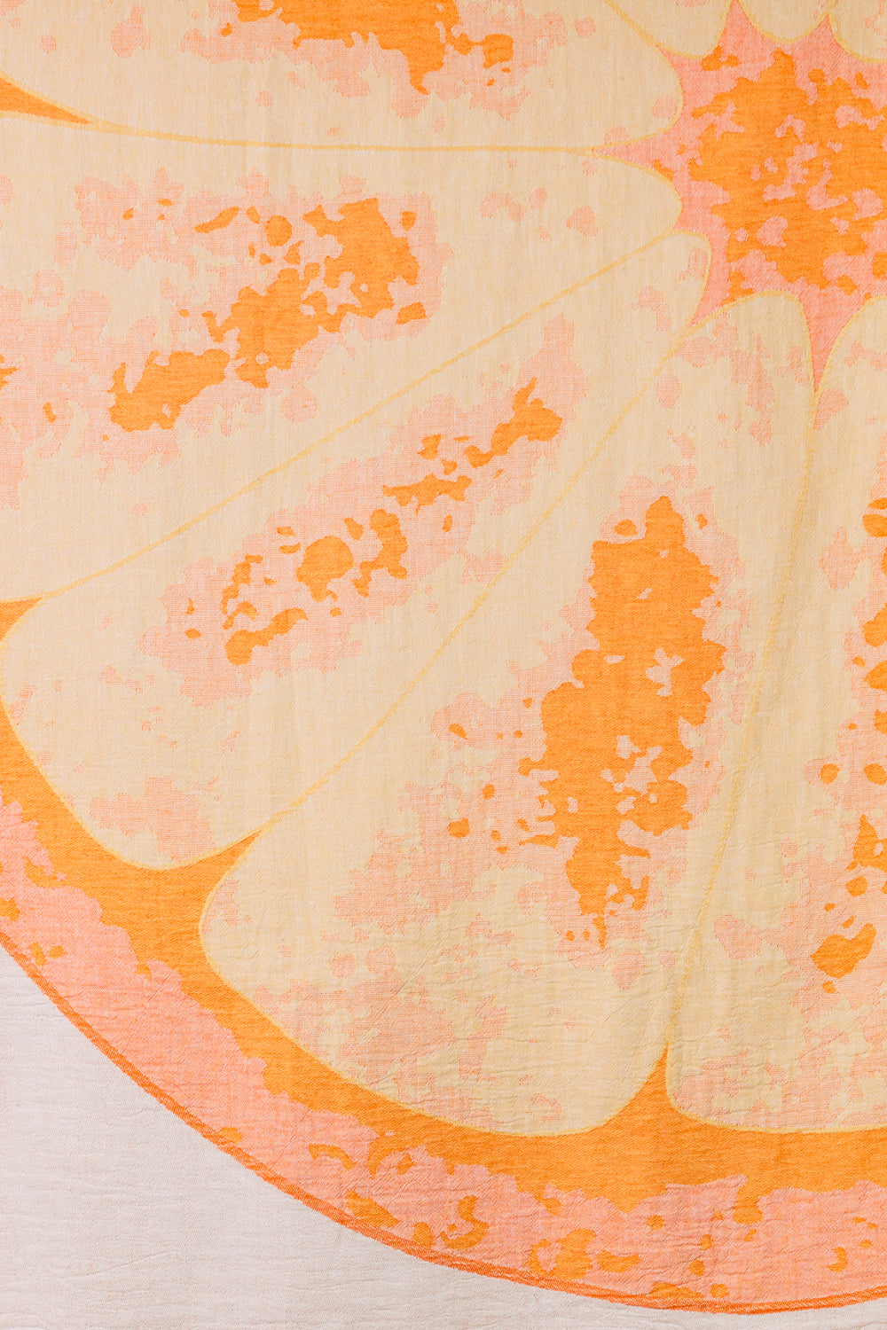 Close-up of a printed beach towel showing a sliced orange with juicy interior and vibrant color.