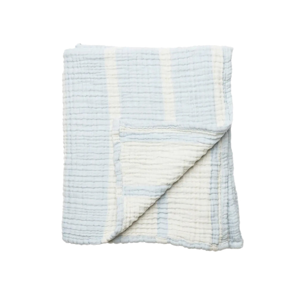 Stack of colorful baby blankets on a wooden stool against a white background