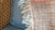 Close-up of textured fabric with frayed edge and a cushion in the background