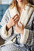 Woman in a blue checkered fleece spa robe in a hotel room