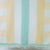 A beach towel with pastel yellow, seafoam green, and white stripes, with fringed edges, displayed on a vertical surface.