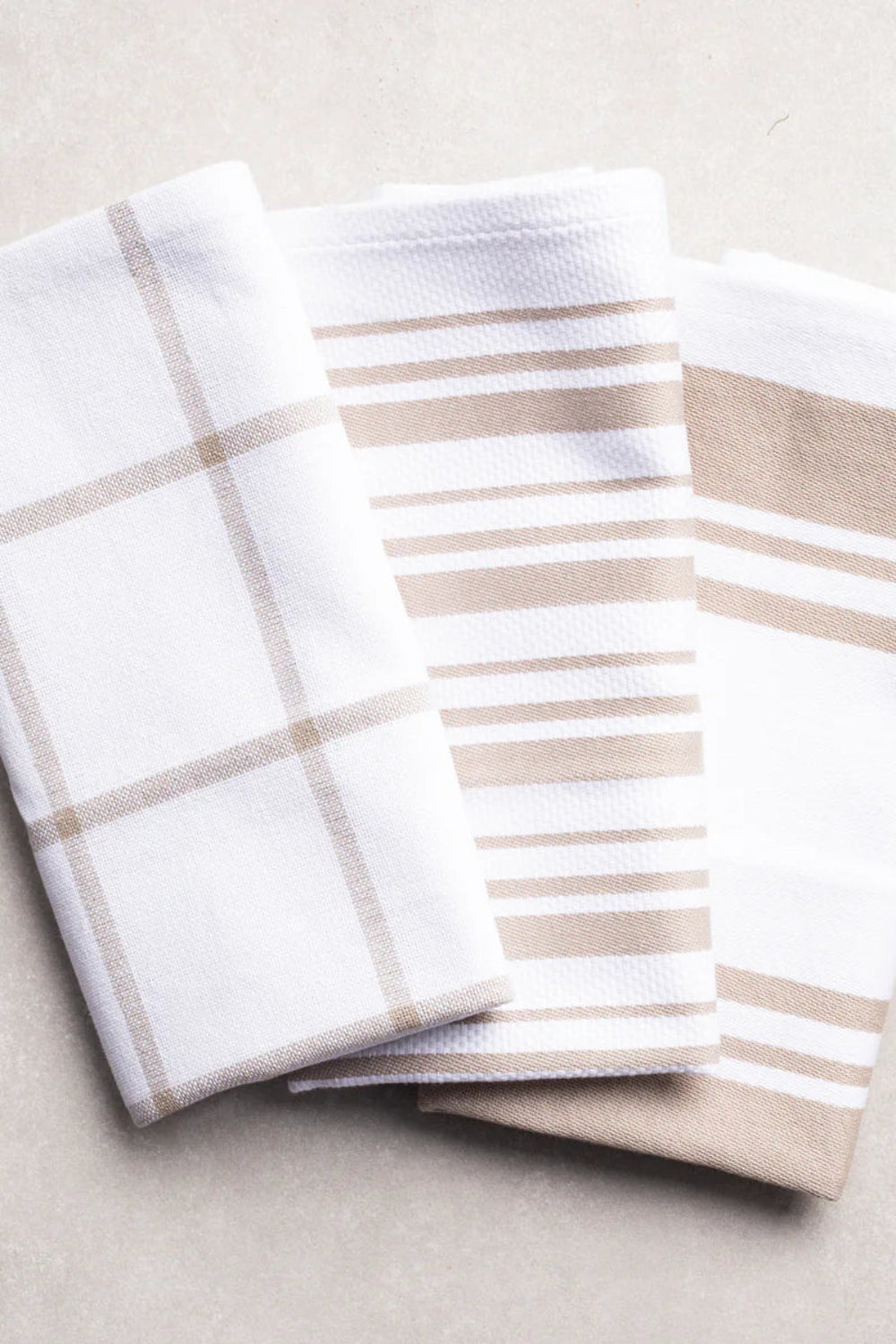 Two folded towels with plaid and striped patterns on a light background