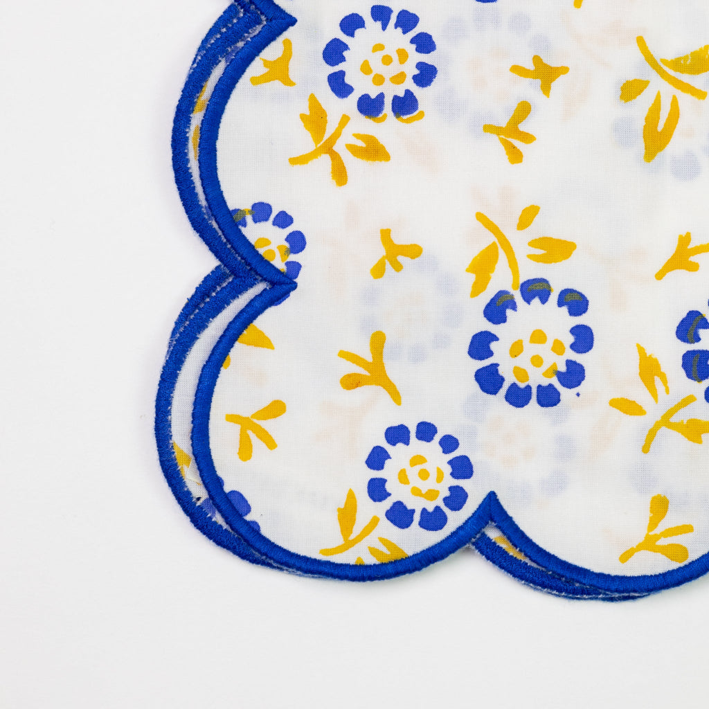 Pair of blue and yellow floral coasters on a white background