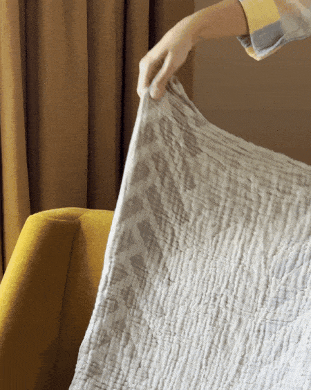 animated image of a throw blanket being tossed over the back of a chair