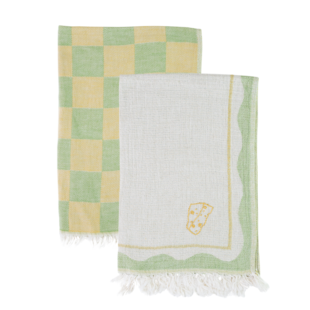 Two towels, one checkered green and yellow, the other white with a logo, on a white background.