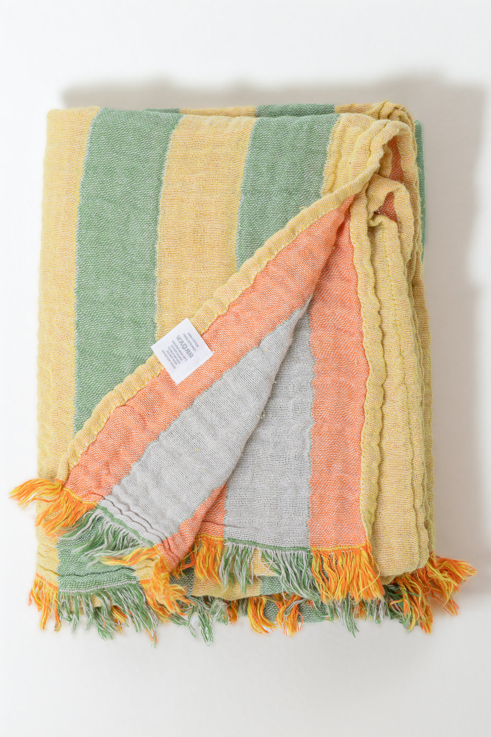 Multicolored striped body towel with frayed edges on a white background