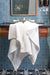 Bathroom with blue tiled walls, wooden vanity, and white towel.