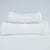 Two white textured towels, one body and one hand, stacked against a white background