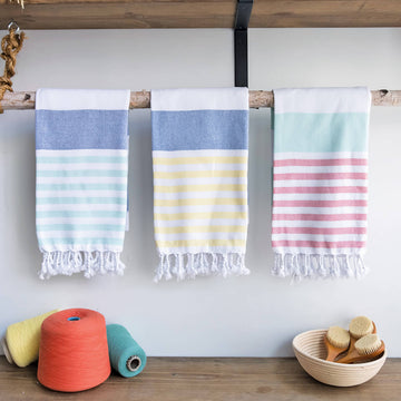 Three Marine Turkish Towels hanging on a display rod